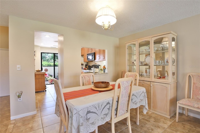 5362 Huntingwood Ct Unit 16, Sarasota, FL 34235 - dining room with an inviting chandelier, a textured ceiling, and light tile patterned floors