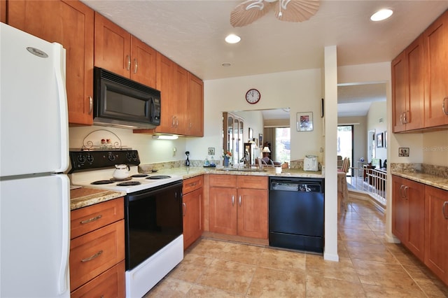 5362 Huntingwood Ct Unit 16, Sarasota, FL 34235 - kitchen featuring brown cabinetry, a ceiling fan, a sink, light stone counters, and black appliances