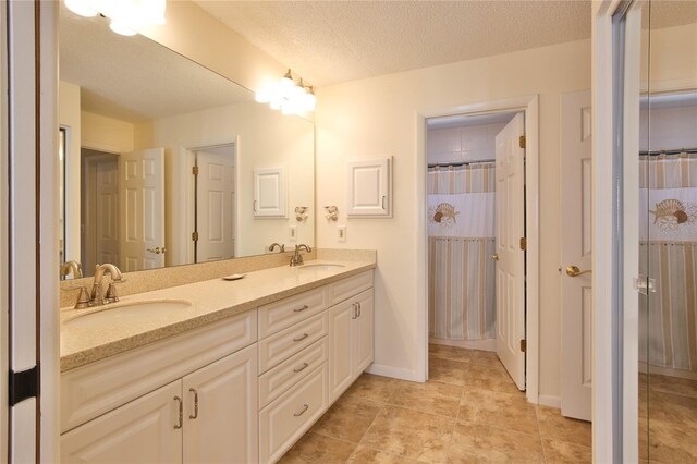 5362 Huntingwood Ct Unit 16, Sarasota, FL 34235 - bathroom featuring double vanity, a textured ceiling, and a sink
