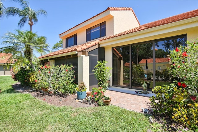 5362 Huntingwood Ct Unit 16, Sarasota, FL 34235 - back of property with a tiled roof, a yard, and stucco siding