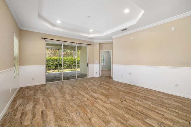11634 Piedmont Park Xing, Bradenton, FL 34211 - spare room featuring a tray ceiling, wood finished floors, recessed lighting, a wainscoted wall, and ornamental molding