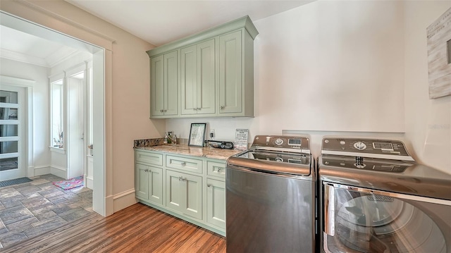 laundry area featuring washing machine and clothes dryer, cabinet space, ornamental molding, and baseboards