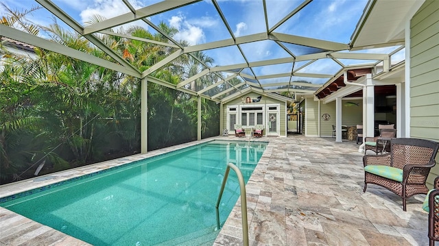 outdoor pool with a patio area, an outdoor structure, and glass enclosure