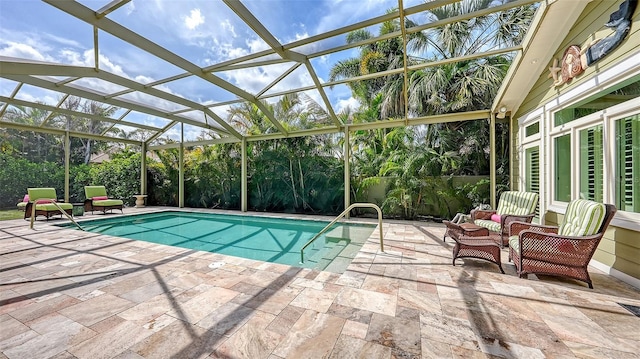 view of pool with a patio area and glass enclosure