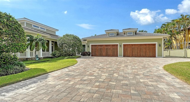 view of front of property with decorative driveway and a garage