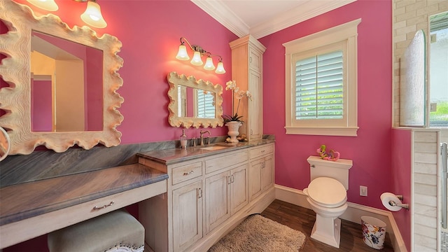 bathroom with toilet, wood finished floors, crown molding, vanity, and baseboards