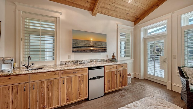 kitchen with a sink, fridge, wood ceiling, light wood-style flooring, and light stone countertops