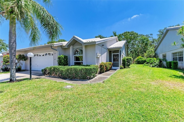 ranch-style house featuring an attached garage, concrete driveway, stucco siding, and a front yard