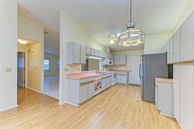 kitchen with a ceiling fan, white appliances, light wood-type flooring, light countertops, and a sink