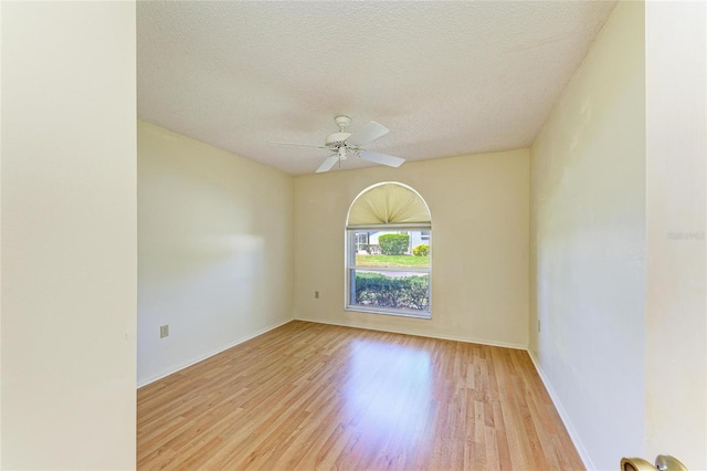 spare room featuring baseboards, a textured ceiling, ceiling fan, and wood finished floors