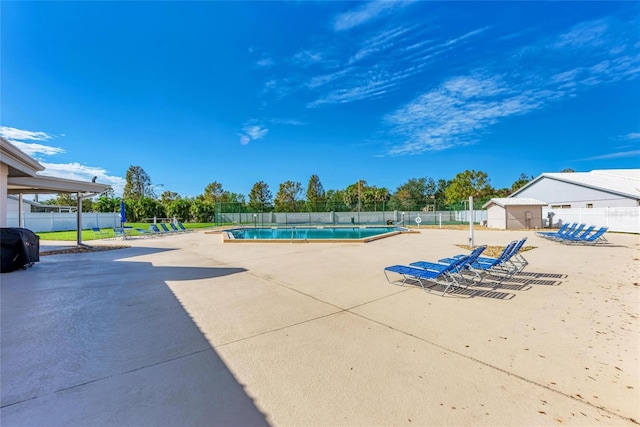 pool with a patio and fence