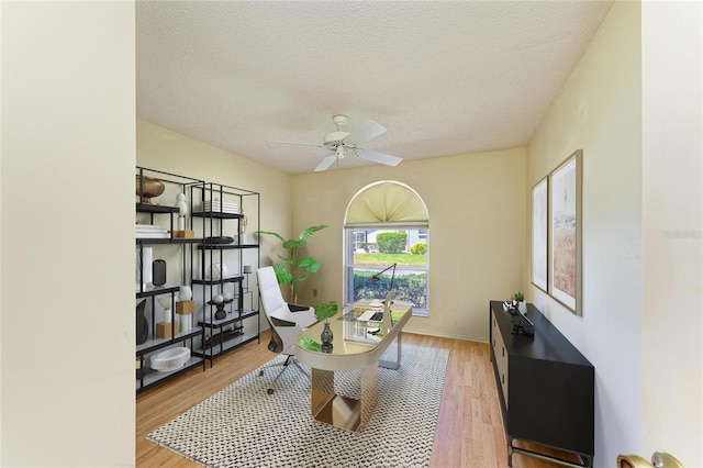 home office featuring a textured ceiling, ceiling fan, and wood finished floors