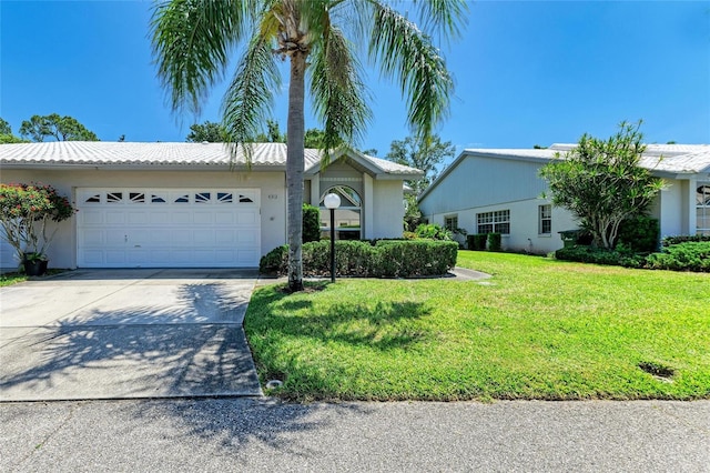 single story home featuring a garage, stucco siding, driveway, and a front yard
