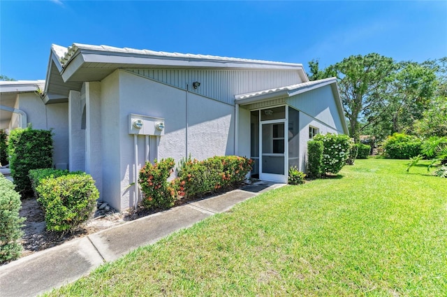 view of property exterior with a lawn and stucco siding