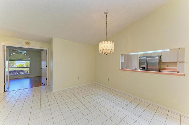 empty room featuring light tile patterned flooring, baseboards, vaulted ceiling, and ceiling fan with notable chandelier