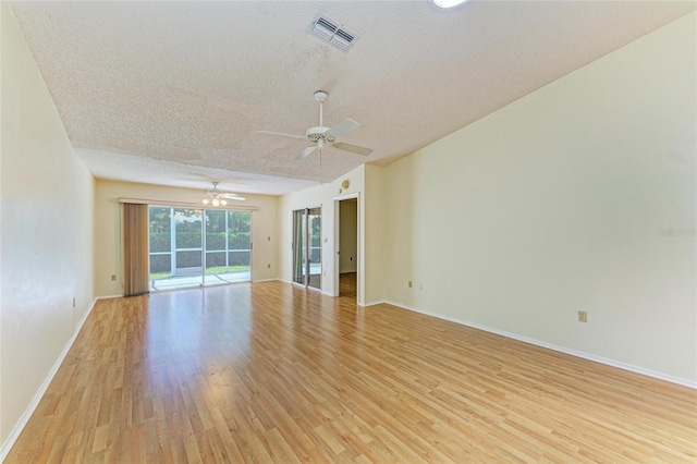 empty room with visible vents, baseboards, ceiling fan, light wood-type flooring, and a textured ceiling