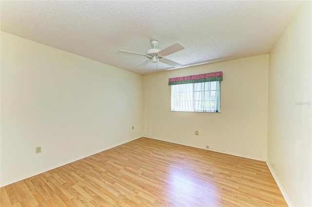 unfurnished room featuring a ceiling fan, light wood finished floors, and a textured ceiling