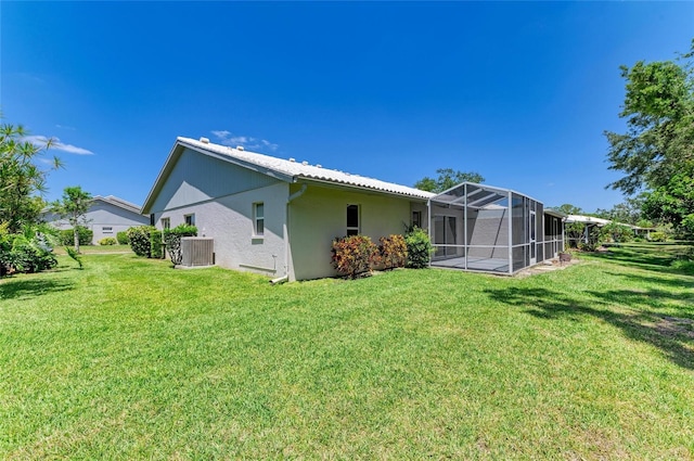 back of property featuring a lawn, glass enclosure, and cooling unit