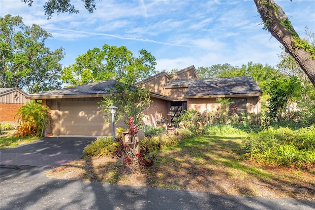 ranch-style home with an attached garage, brick siding, and driveway