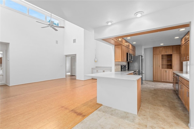 kitchen featuring a ceiling fan, stainless steel appliances, recessed lighting, a peninsula, and light countertops