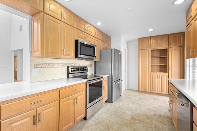 kitchen featuring backsplash, light countertops, stainless steel appliances, and recessed lighting
