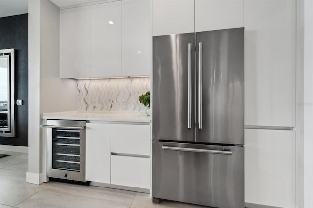 bar featuring freestanding refrigerator, beverage cooler, baseboards, and light tile patterned floors