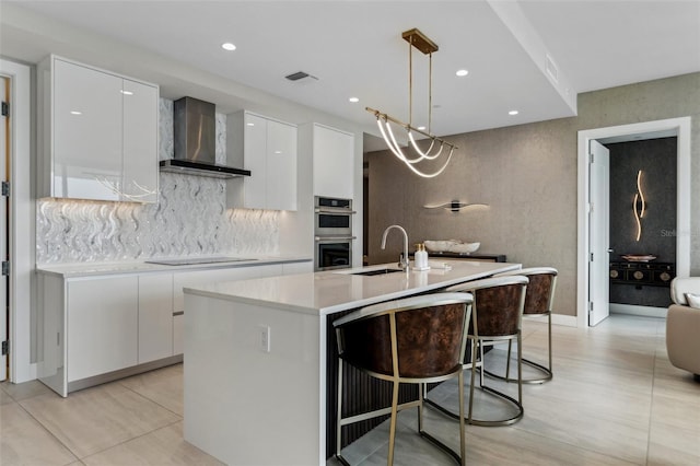 kitchen with wall chimney range hood, a sink, modern cabinets, double oven, and light countertops