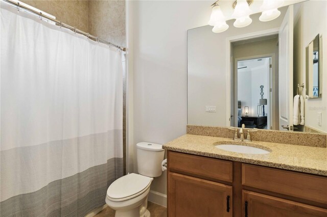 ensuite bathroom with vanity, toilet, a chandelier, and a shower with curtain
