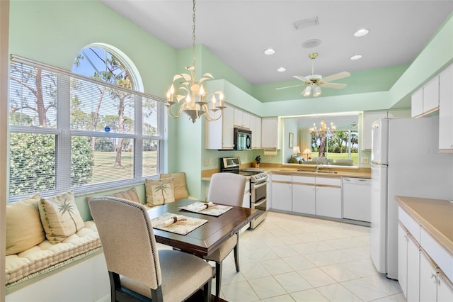 interior space featuring white appliances, light countertops, white cabinets, a sink, and ceiling fan with notable chandelier