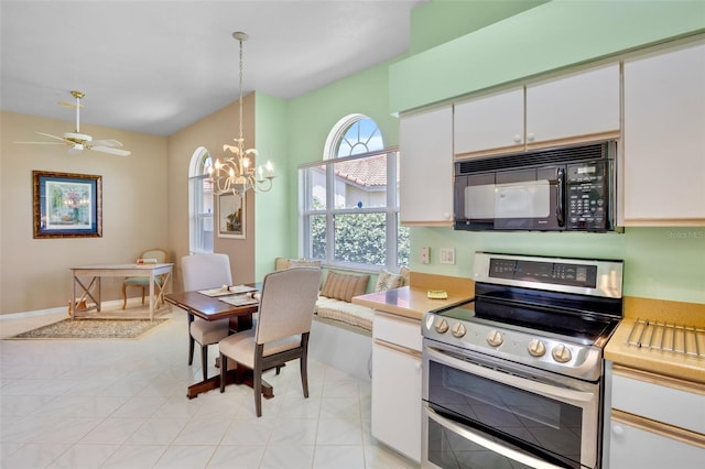 kitchen featuring black microwave, light countertops, white cabinetry, double oven range, and pendant lighting