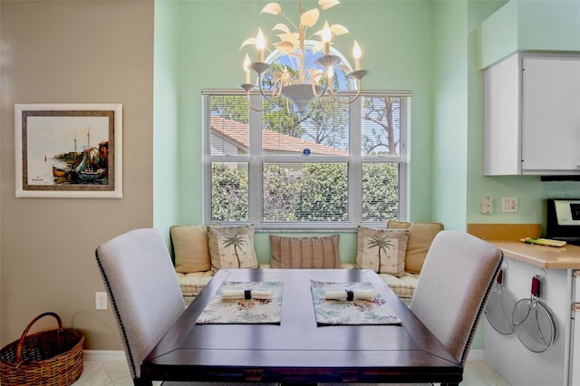 dining room with light tile patterned floors, baseboards, and a chandelier