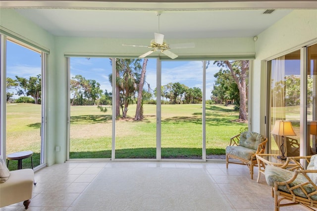 sunroom / solarium featuring ceiling fan, plenty of natural light, and tile patterned flooring