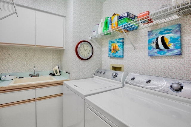 washroom featuring a sink, independent washer and dryer, and wallpapered walls