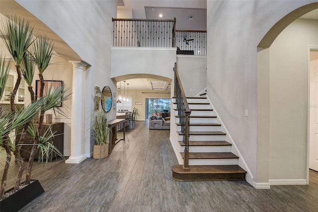 6001 Anise Dr, Sarasota, FL 34238 - foyer entrance with a high ceiling, arched walkways, stairs, baseboards, and wood finished floors