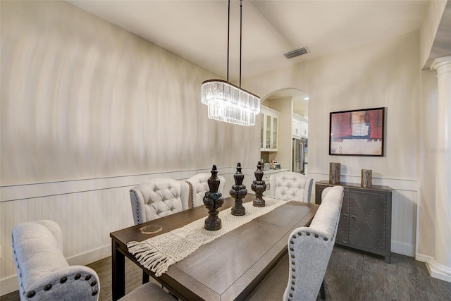 6001 Anise Dr, Sarasota, FL 34238 - dining area with a notable chandelier, wainscoting, arched walkways, wood finished floors, and visible vents