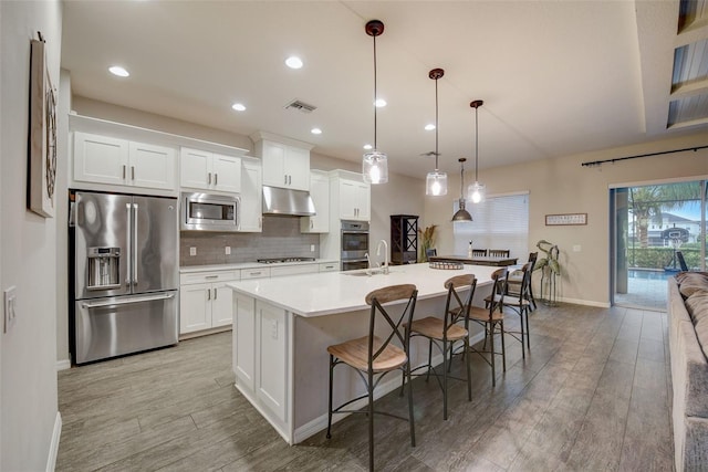 6001 Anise Dr, Sarasota, FL 34238 - kitchen featuring visible vents, baseboards, under cabinet range hood, light wood-style flooring, and stainless steel appliances