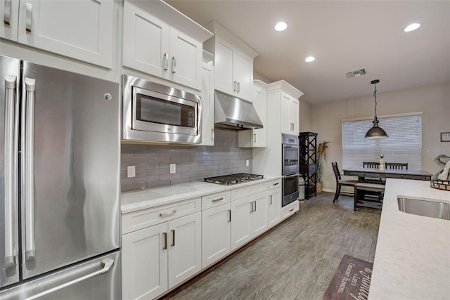 6001 Anise Dr, Sarasota, FL 34238 - kitchen featuring a sink, light countertops, stainless steel appliances, under cabinet range hood, and visible vents