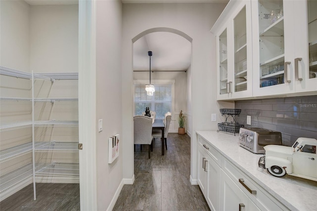 6001 Anise Dr, Sarasota, FL 34238 - interior space featuring baseboards, arched walkways, dark wood-style flooring, and a toaster