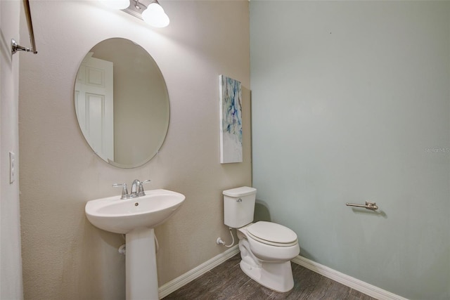 6001 Anise Dr, Sarasota, FL 34238 - bathroom featuring toilet, baseboards, a sink, and wood finished floors