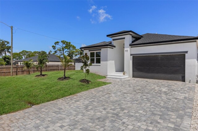 532 Yale Rd, Venice, FL 34293 - prairie-style house featuring a garage, decorative driveway, fence, a front lawn, and stucco siding