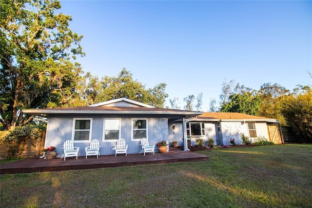 back of house featuring a lawn and a deck