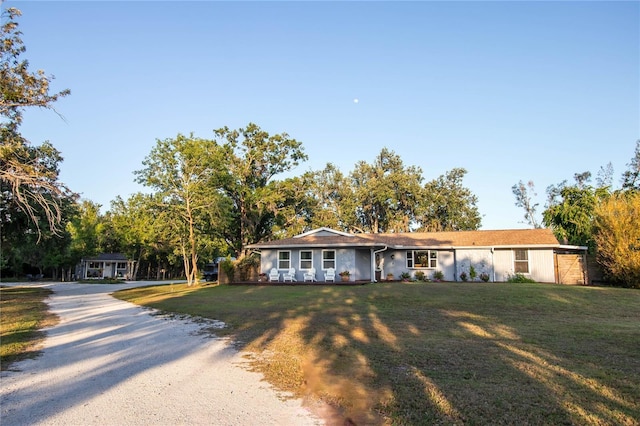 ranch-style house with driveway and a front yard