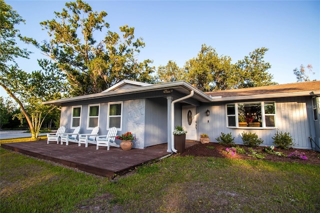 view of front of house featuring a wooden deck and a front yard