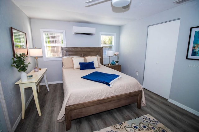 bedroom with multiple windows, a wall mounted AC, and wood finished floors