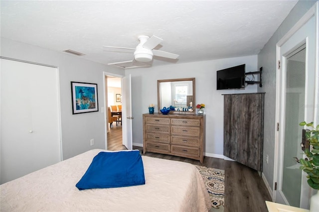 bedroom featuring a ceiling fan, baseboards, visible vents, and wood finished floors