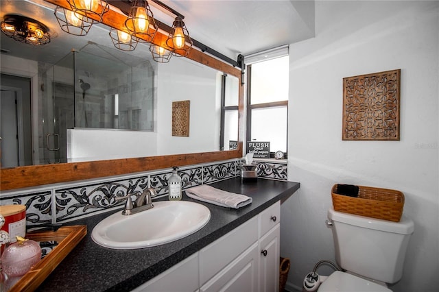 bathroom with vanity, a stall shower, and toilet