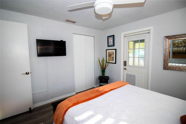 bedroom featuring a ceiling fan, visible vents, dark wood finished floors, baseboards, and a closet