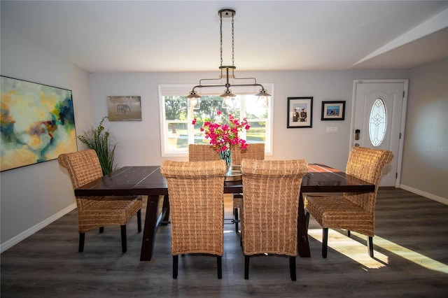 dining space with baseboards and dark wood finished floors