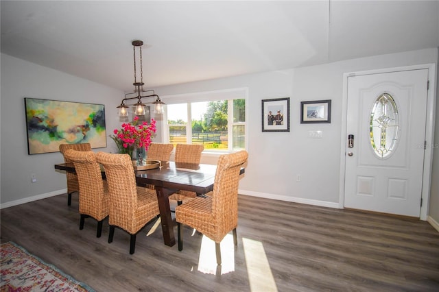 dining area with baseboards, lofted ceiling, and wood finished floors