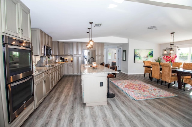 kitchen featuring visible vents, wood finished floors, gray cabinets, appliances with stainless steel finishes, and vaulted ceiling